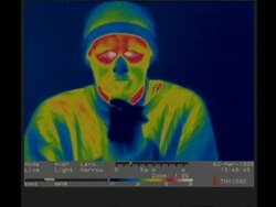 Thermographic imaging, CU man warms hands by blowing on them, removes hat Stock Footage
