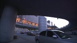 Traffic passes under a highway ramp near the Beijing West Railway Station. Stock Footage