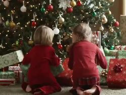 two children running towards their presents on Christmas morning Stock Footage
