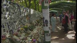 Mourners and missing posters on wall News Clip