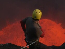 Climber watches lava erupting from volcano, Marum Volcano, Ambrym Island, Vanuatu Stock Footage