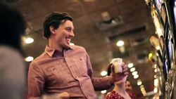 Young guy wins big at casino slot machine, kisses young woman and celebrates with friends Stock Footage