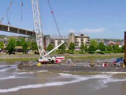 WS Crane lifted with bridge segment moving ahead with Mosel river, deconstruction of bridge / Wellen, Rhineland Palatinate, Germany Stock Footage