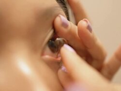Asian woman wearing contact lens in a bathroom Stock Footage