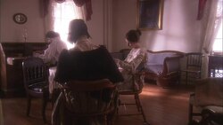 A man and two women sit in a 19th century sitting room. Stock Footage