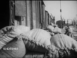 1953: KARACHI, WEST PAKISTAN: VS Burlap bags of surplus product for export being unloaded from railroad train cars. Angled WS 'Pak Mail Express' locomotive ('Fakhar-E-Pakistan' w/ half moon w/ star) moving slowly forward along station platform. Instructional Video