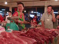 MS POV SLO MO Woman at counter in meat market sharpening knife / Vientiane, Laos Stock Footage