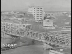 1936: COMMONWEALTH of the PHILIPPINES: HA WS Bridge w/ traffic, people, General Electric building w/ 'GE' sign BG. WS 'Tokyo Bazar' on building w/ horse drawn carriages on road FG. WS 'Osaka Bazar' on building. WS Quiapo Church in Manila w/ traffic FG Instructional Video