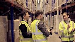 Supervisor and workers taking inventory in distribution warehouse Stock Footage