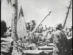 1943: BETIO, TARAWA: RAISING US FLAG: WS Marines gathered on beach, raising American flag on rope tied to coconut tree. VS Marines saluting.   (Time-Life War Correspondent Robert Sherrod describes) WWII, World War II. Instructional Video