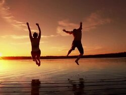 Young adult couple jumps into lake. Stock Footage