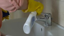Housewife applying detergent to tap, desire to get rid of rust and stains, duty Stock Footage