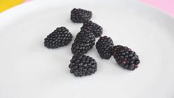 closeup of blackberries on a white rotating plate Stock Footage