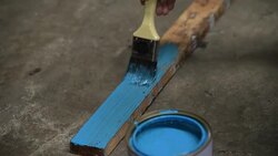 Human hand is painting blue color on wooden stick Stock Footage