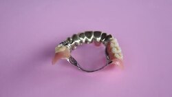 Dentures on a rotating pink plate Stock Footage