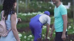 Tall gardener shows flower to customers in the garden Stock Footage