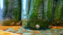The housewife pours hot marinade into a glass jar with cucumbers. Stock Footage
