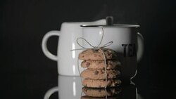 Breton gift biscuits and a cup of tea on a black background with steam. Stock Footage
