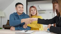 Asian happy couple getting key with realtor agent and handshake with smiling face at new home.buying new house real estate Stock Footage