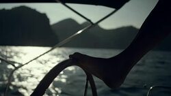 Woman steers the yacht with leg. Close-up Stock Footage