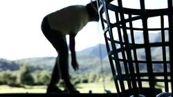 Golfer in Silhouette Hitting the Golf Ball with Iron Club on Driving Range Stock Footage