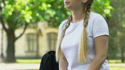 Upset girl waiting for boyfriend or classmates, outsider among teenagers, lonely Stock Footage