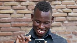 portrait of Smiling american african man scrolling his smartphone. Technology,communication, Stock Footage