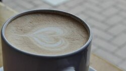 A mug of coffee on a table by the window in a cafe. Stock Footage