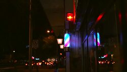 slow motion lighted barber pole spinning with nighttime traffic behind Stock Footage