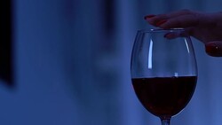 Female hand touching glass with red wine, seduction and flirt, romantic date Stock Footage