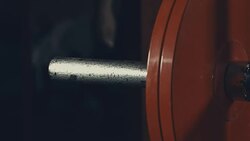 Strong male athlete adding weight plate to bar in gym Stock Footage
