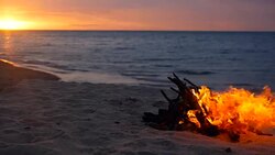 Blazing campfire on the beach during summer evening. Bonfire in nature as background. Burning wood on white sand shore at sunset. selective focus. tropical romantic landscape near sea water edge. Stock Footage