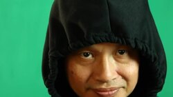 Thai man in hood with green background Stock Footage
