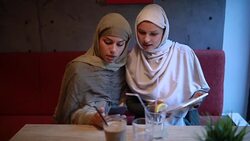 Muslim students enjoying their time at a cafe together Stock Footage