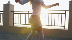 Young stylish attractive woman skateboarding at sunrise on seafront, slow motion, close up shot Stock Footage