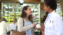 Pharmacist selling medicine to female customer Stock Footage