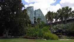 Low Angle Panning and Moving Across Video of Cone Shape Glass Greenhouse Stock Footage