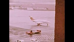 Private plane on runway at Munich Airport. Photo of man. Man speaks to camera. Tower on building, 1972 Stock Footage