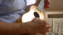 Man playing ukulele in 4K slow motion 60fps Stock Footage