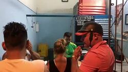 Santa Clara, Cuba: A small line up of people for buying milk at the butcher's shop Stock Footage
