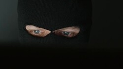 Head of thief in a black mask (balaclava) before a computer Stock Footage