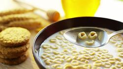on a sunny day in the garden pours cereals in a cup where the cereals falls in slow motion . concept of healthy food and breakfast of milk and bisquits or cookies and cereals. bio food Stock Footage