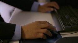 Short clip showing hands working at a desktop computer. Stock Footage