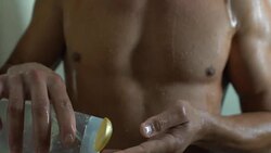 Manly guy taking shower with body wash, hygiene products for men, bathroom Stock Footage