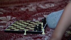 Hands close-up of a child arranging black chess pieces on the chessboard Stock Footage