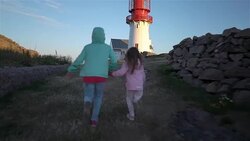 Two little girls play on a rocky northern seashore. Stock Footage