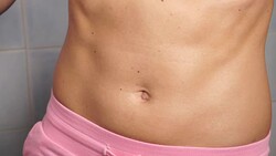 Woman showing some strong abs and flat belly close up 4K Stock Footage