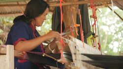 Traditional textile manufacture in craft village where old women work on wooden weaving loom machines and spin yarn creating silk or cotton fabric. Silk weaving in Thailand. Stock Footage