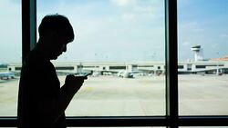 Young Asian man using mobile phone touchscreen and talking on phone. working on the phone, in the background of a Airport , planes, Concept: new business, travel, communication. Stock Footage