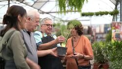 Family shop for plants with Salesman at Flower Market Stock Footage